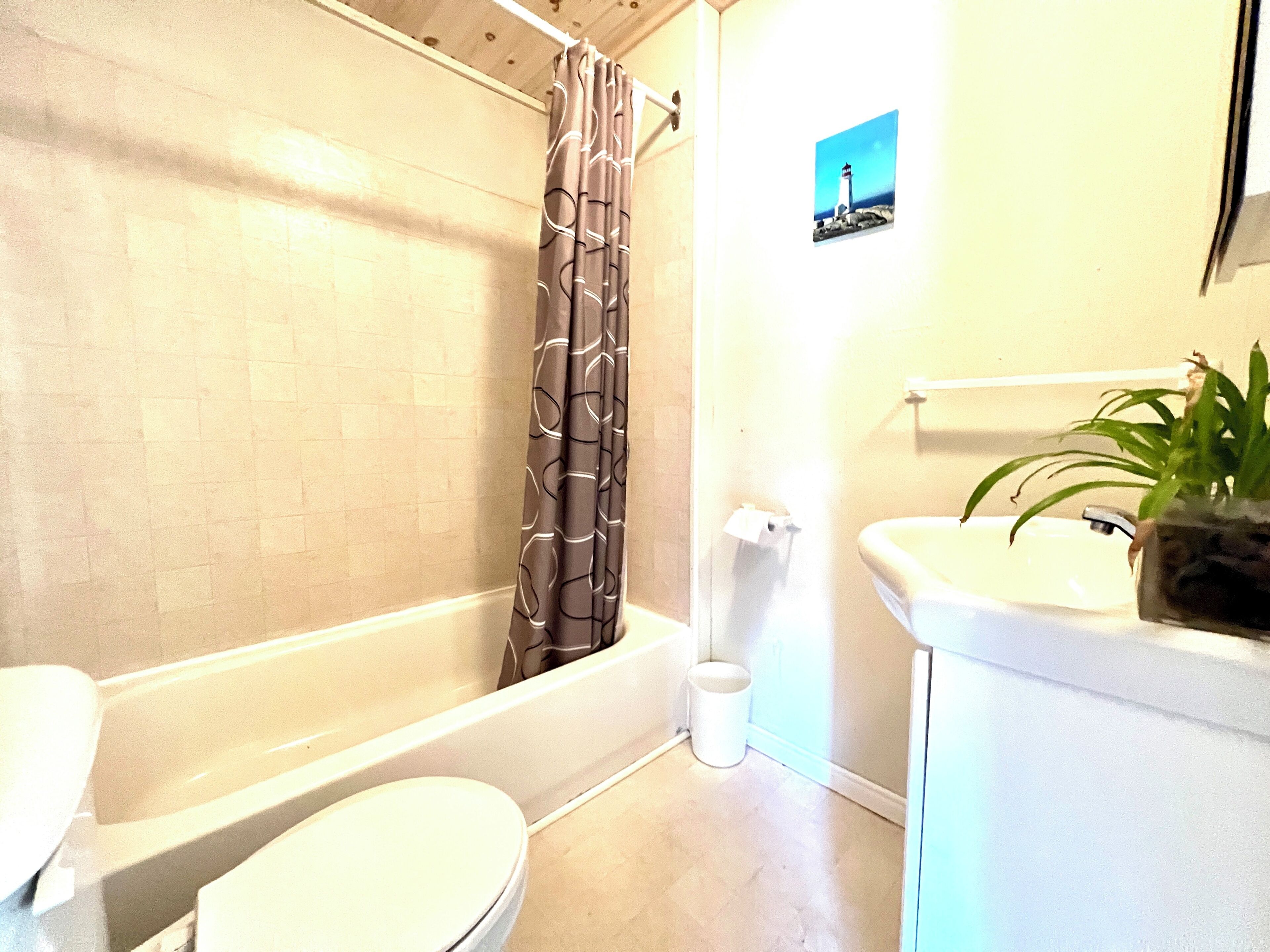 A bathroom with a bathtub, toilet, and sink.