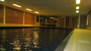 Una piscina cubierta, tumbonas