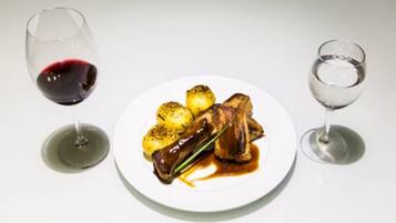 Un plato de comida con una copa de vino tinto y una copa de vino blanco.