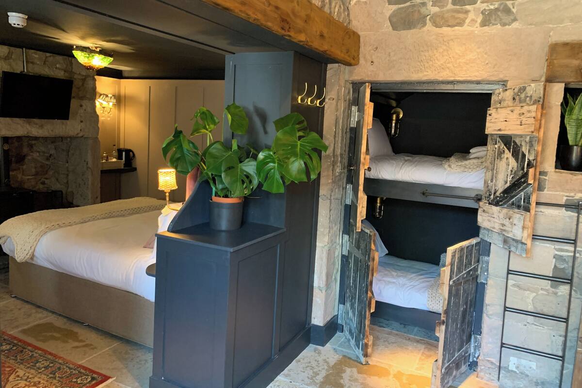 Une pièce chaleureuse avec un lit, une cheminée intégrée et un mur en pierre.