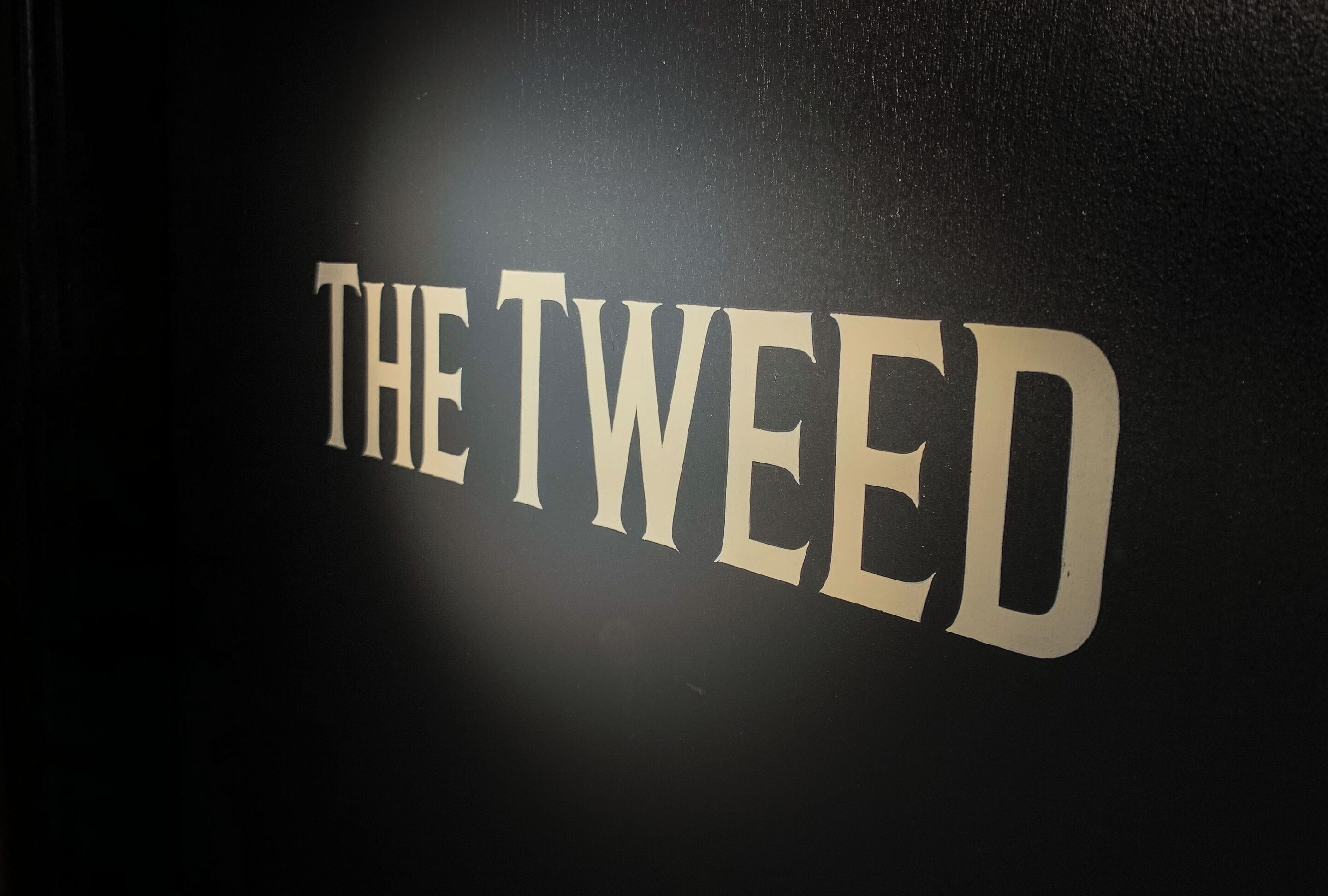 Et skilt med teksten 'THE TWEED'.