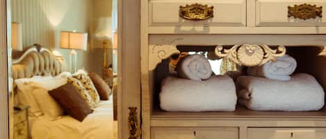 A bedroom with a bed, a nightstand, and a dresser with multiple drawers and decorative handles.