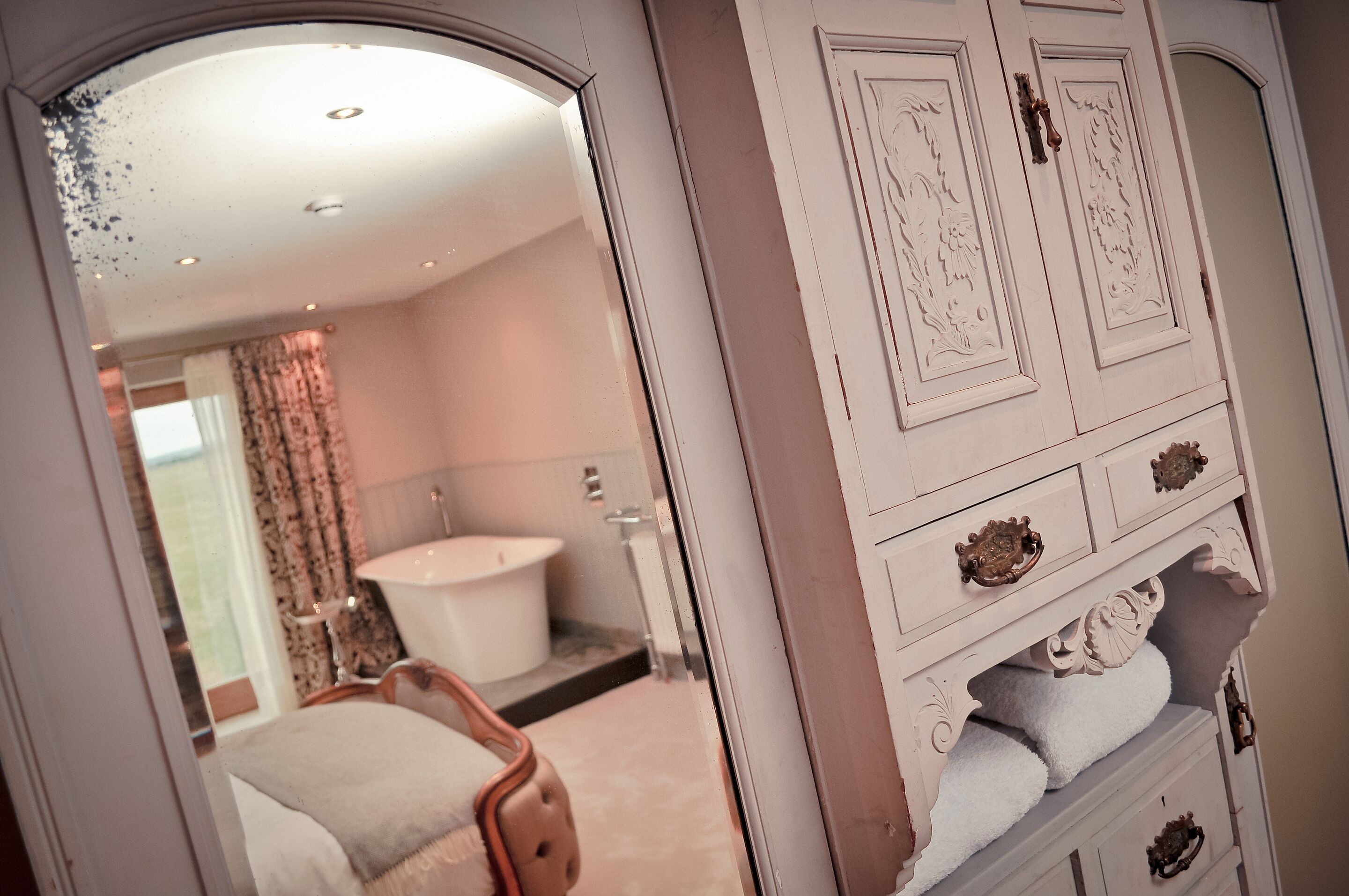 A bathroom with a bathtub, a sink, and a mirror.