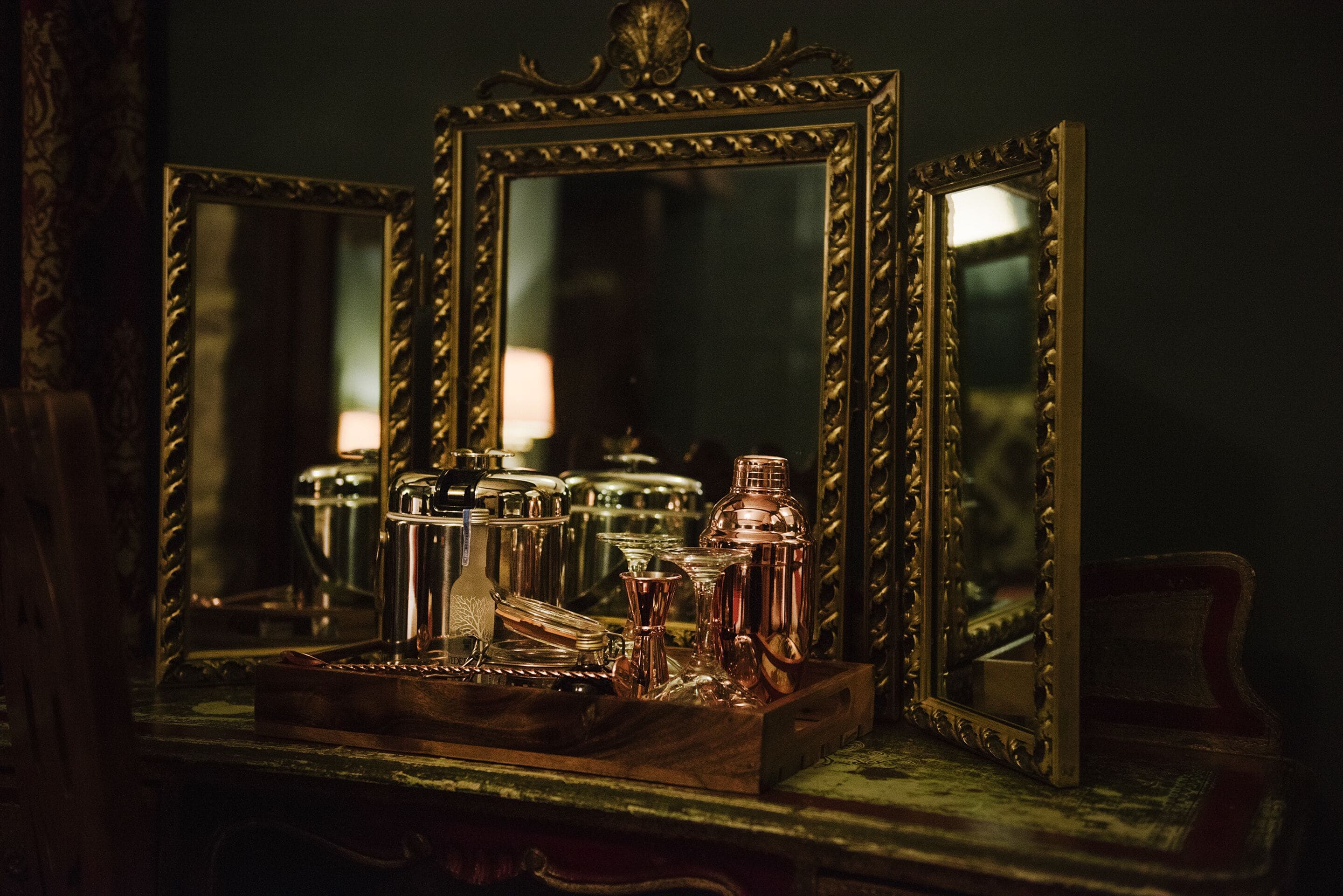 A wooden dresser with a mirror and various glass containers.