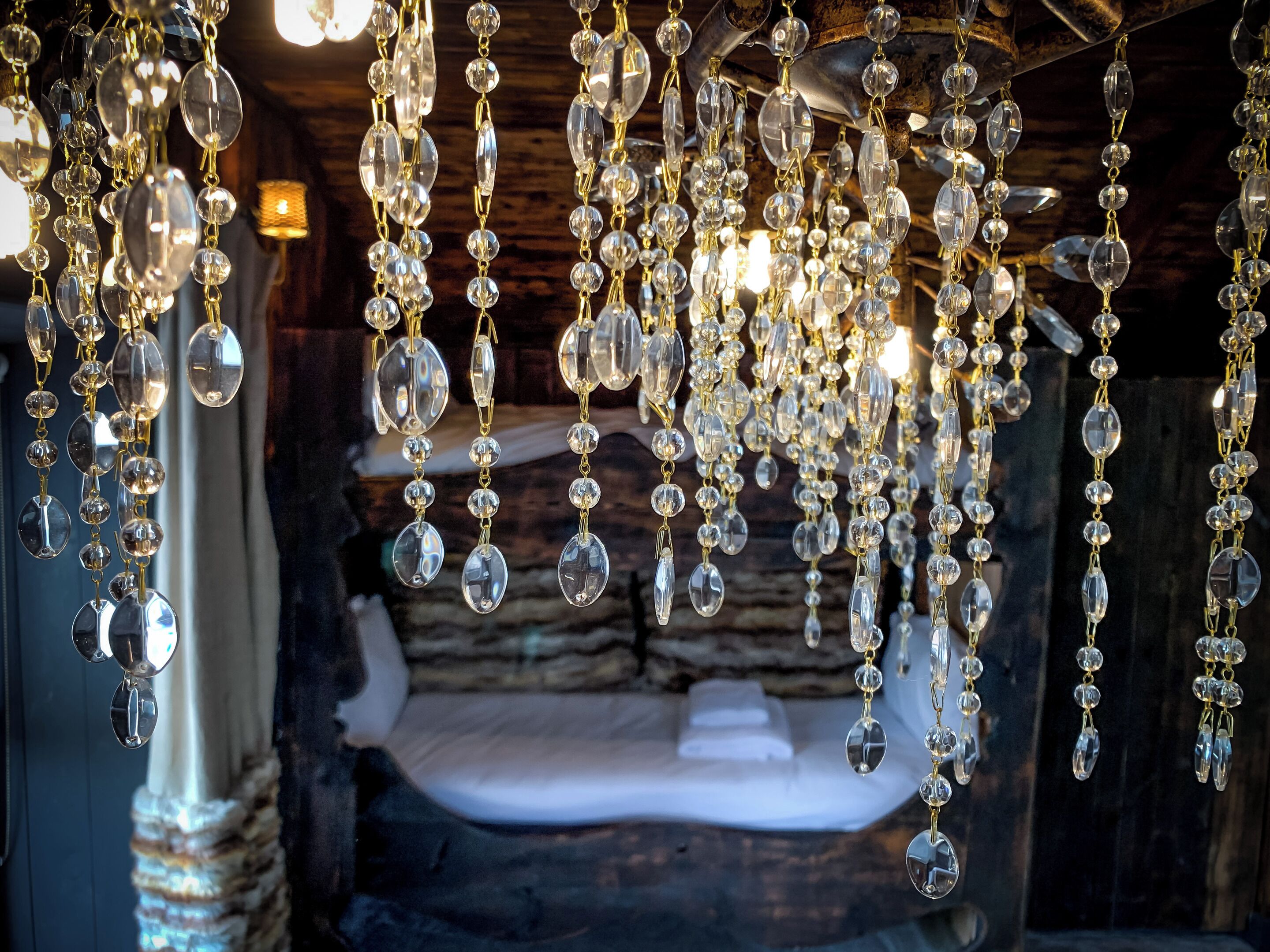 A room with a rustic wooden ceiling and hanging crystal chandeliers.