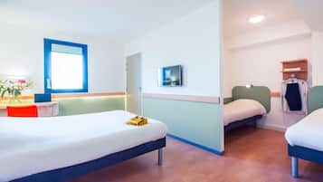 A hotel room with two beds, a desk with a chair, a TV, and a window.