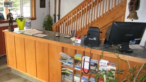 A reception desk with a computer, a phone, and a plant. - Gateway Motel (Radium Hot Springs)