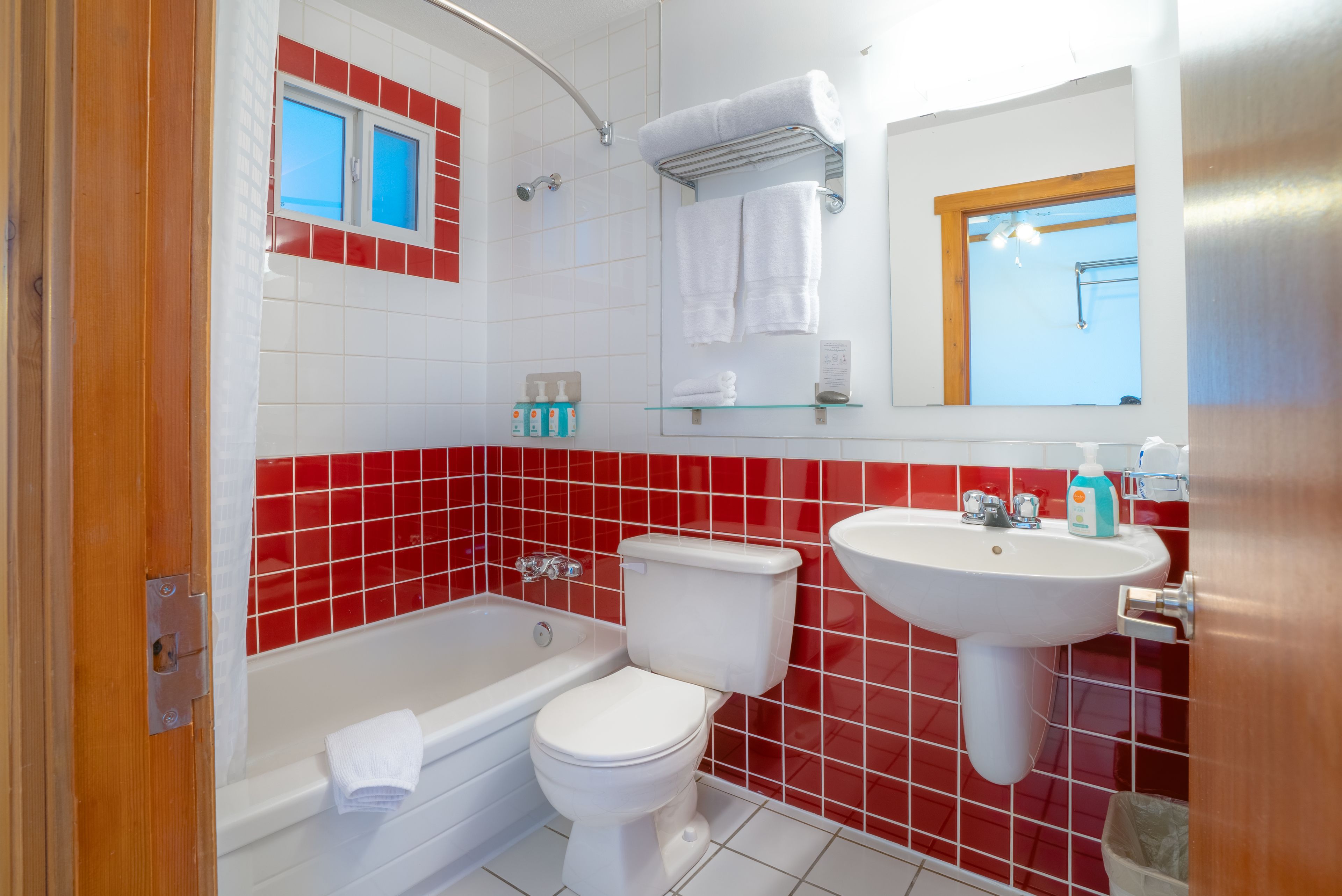 Un baño con bañera, inodoro y lavamanos, todo en color blanco.