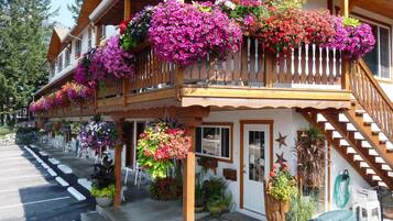 Un edificio de madera con un balcón decorado con cestas de flores colgantes.