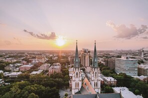 Eine Kirche mit zwei Türmen, umgeben von städtischen Gebäuden und Grünflächen.