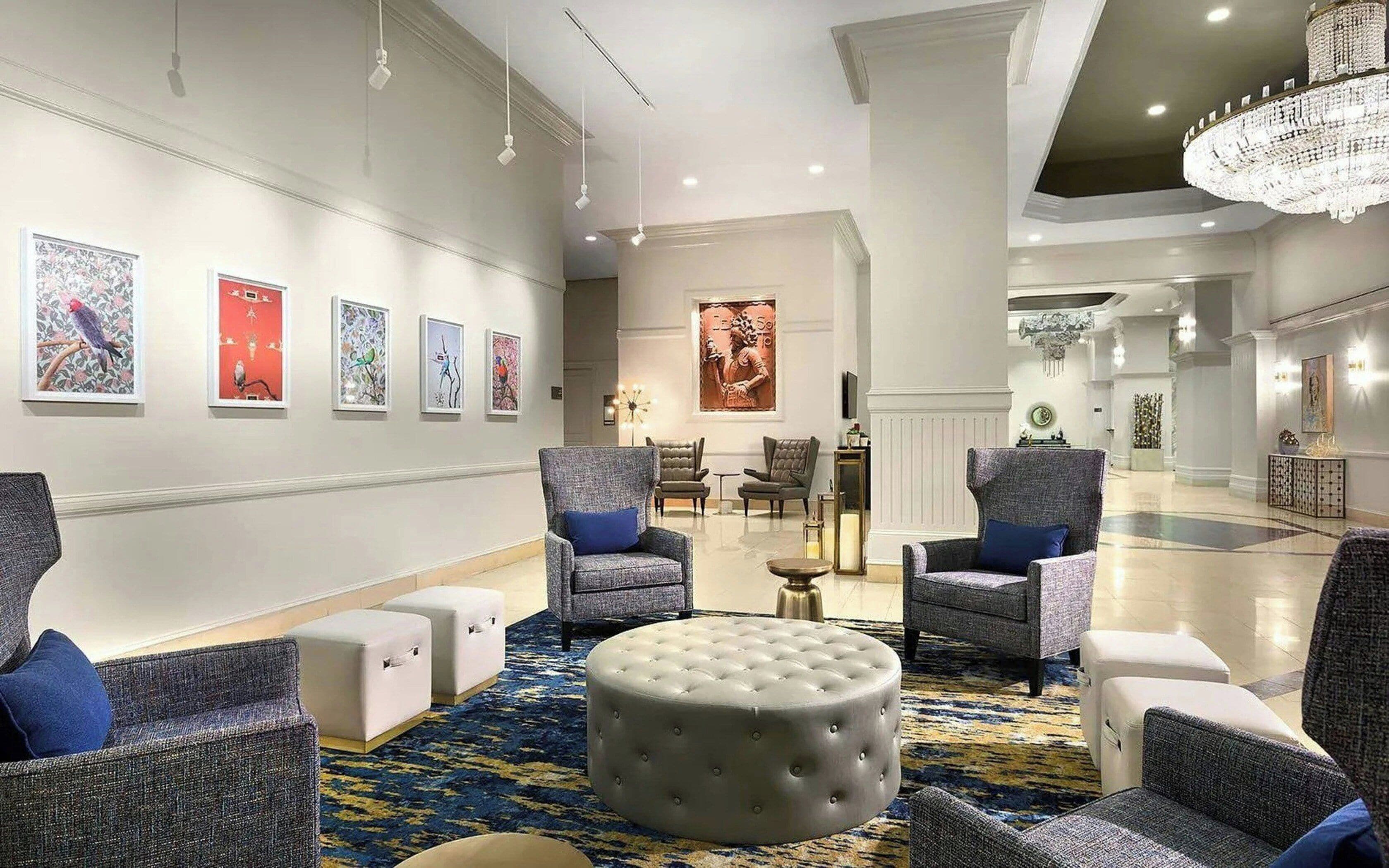 A spacious lobby with a high ceiling, modern furniture, and artwork on the walls.