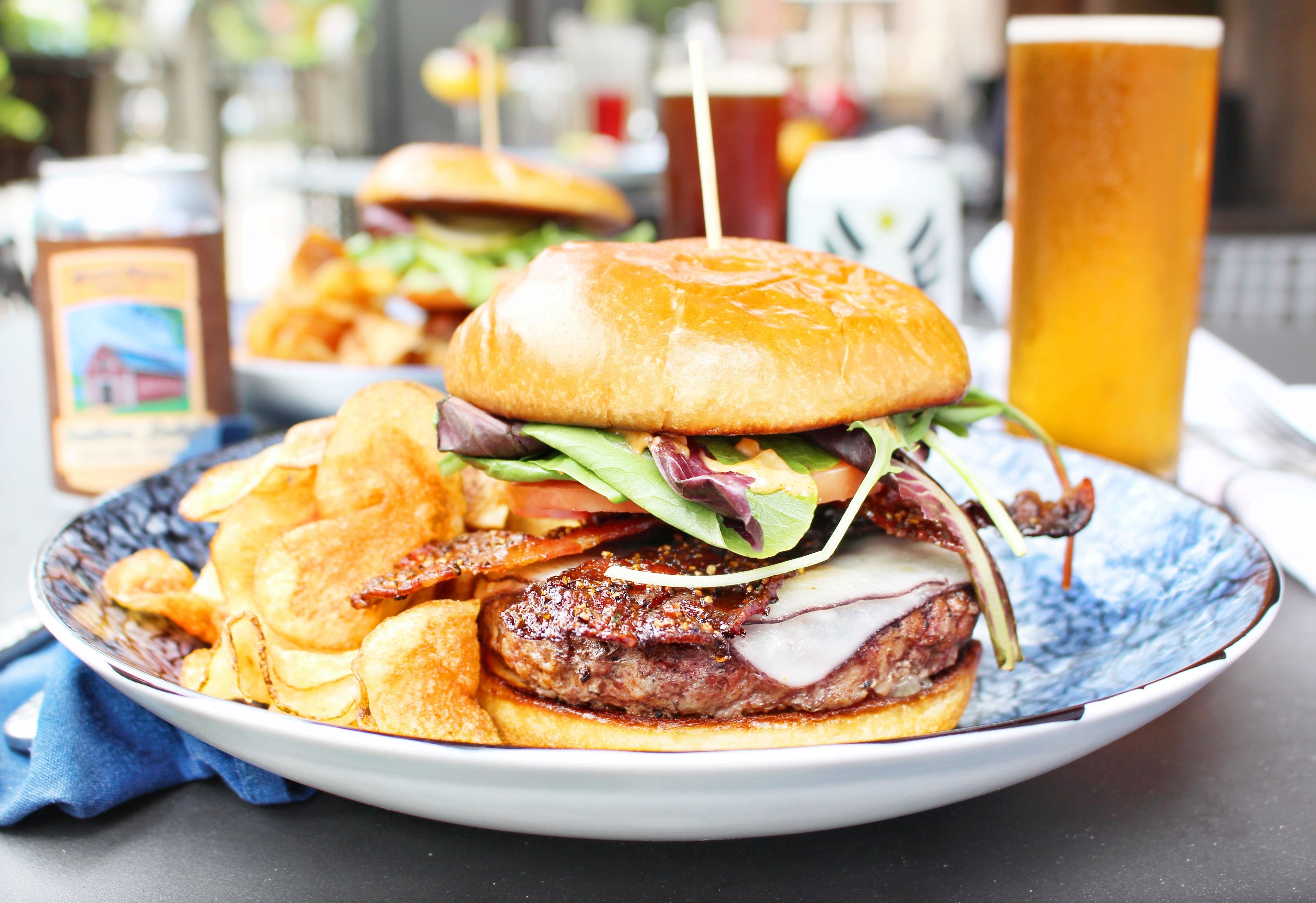 Un plato con una hamburguesa, papas fritas y una bebida.