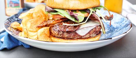 Un plato con una hamburguesa, papas fritas y una bebida.