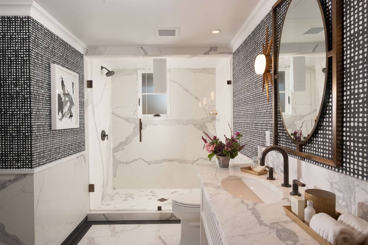 A modern bathroom with a shower, toilet, and sink.