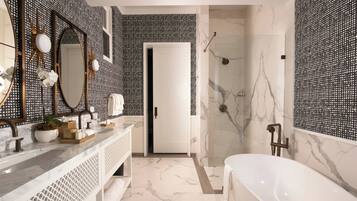 A modern bathroom with a marble floor, a freestanding bathtub, and a large mirror with decorative elements.