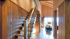 A wooden interior with a staircase, wooden walls, and a hallway leading to a seating area. - Hills Terrace Hakodate (Mori)
