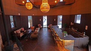 A cozy interior with a central seating area, a bar, and a fireplace. - Hills Terrace Hakodate (Mori)