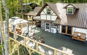 Een chalet met een terras, zitplaatsen buiten en een overdekt gedeelte.