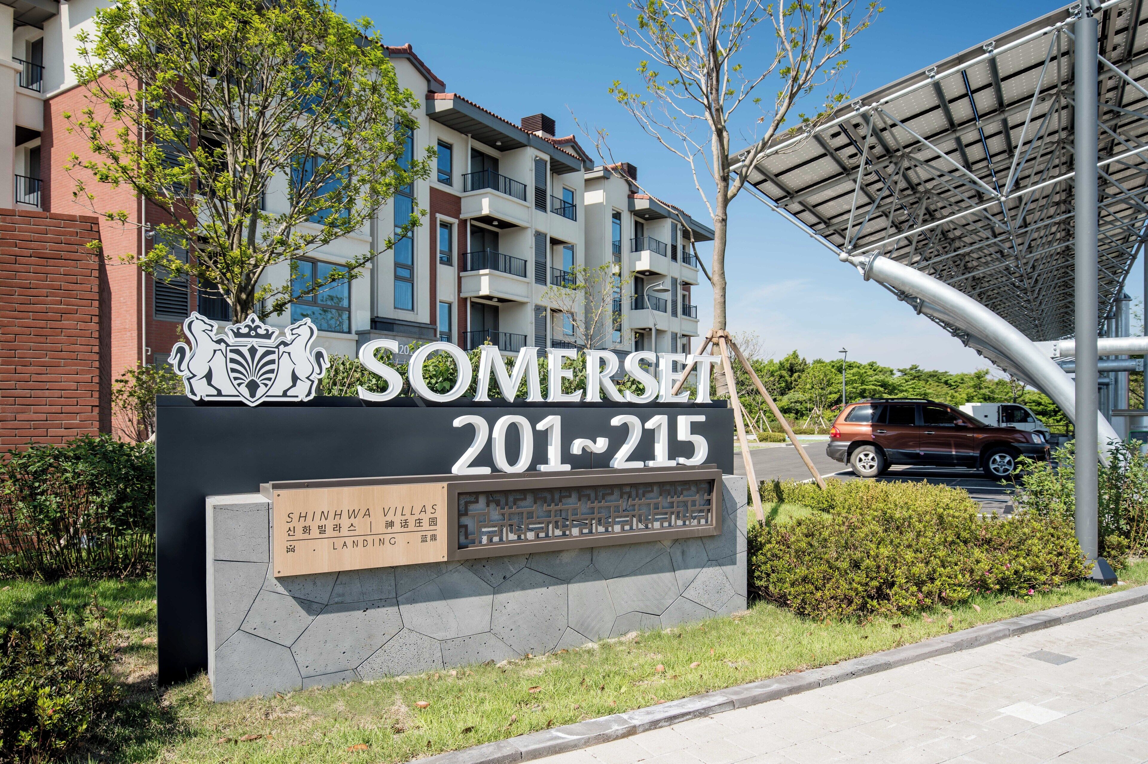 Un letrero para los apartamentos Somerset, con un diseño moderno, que incluye un gran número de exhibición y un logo.