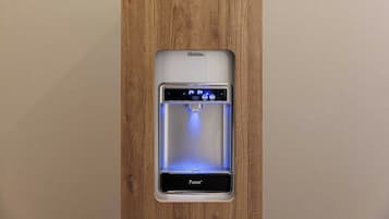 Un dispensador de agua con pantalla digital, marca 'Purest', instalado en un panel de madera.
