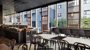 A modern restaurant with a long counter, multiple seating areas, and large windows offering views of the city. - Four Points Flex by Sheraton Kanazawa (Kanazawa)