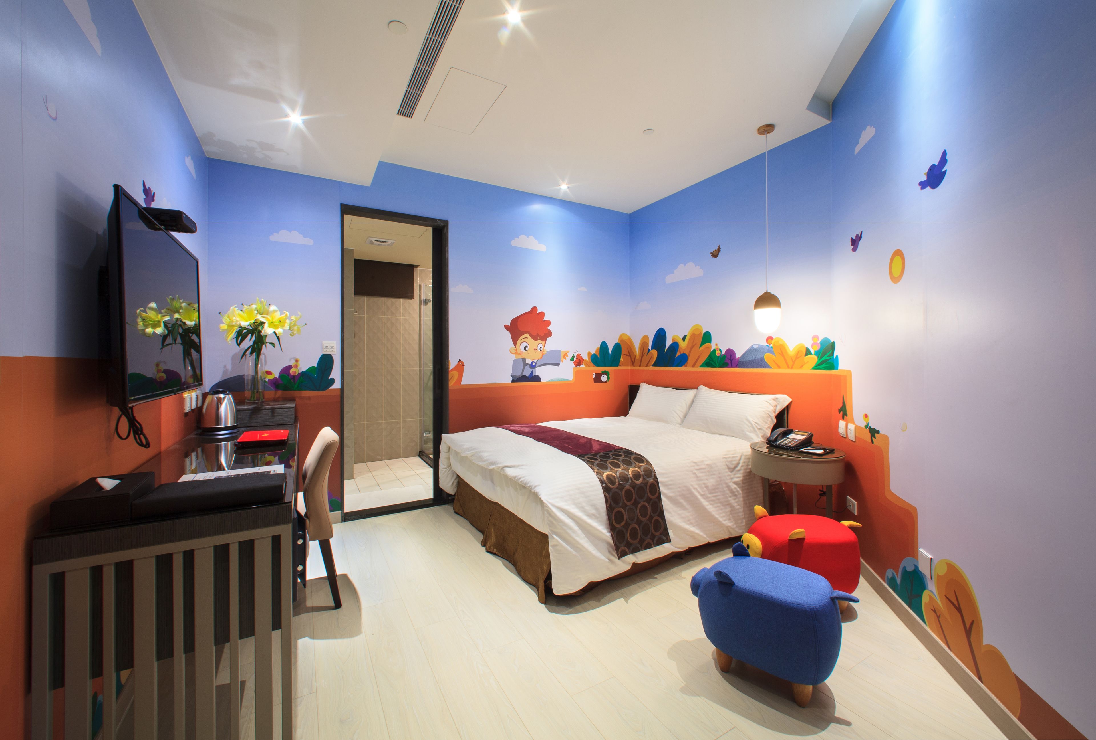 A bedroom with a bed, a desk, a chair, a TV, and a crib.