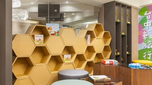 Een modern interieur met honingraatvormige schapunits, een flatscreen televisie en een receptiebalie.