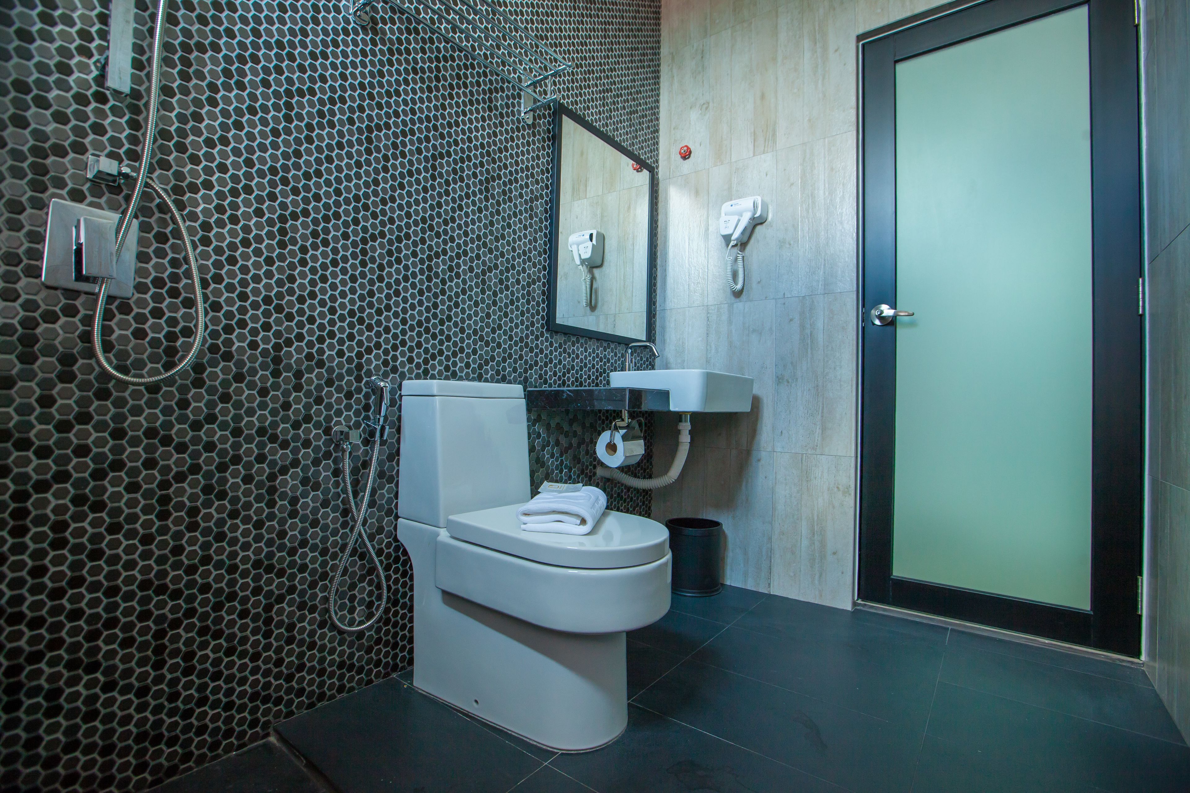 A modern bathroom with a toilet, sink, and mirror.