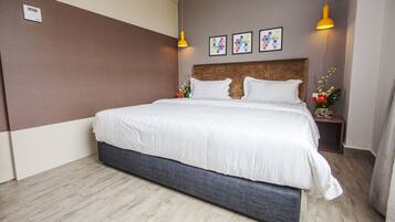 Een moderne hotelkamer met een groot bed, een hoofdeinde, twee nachtkastjes met lampen en een wandthermostaat.