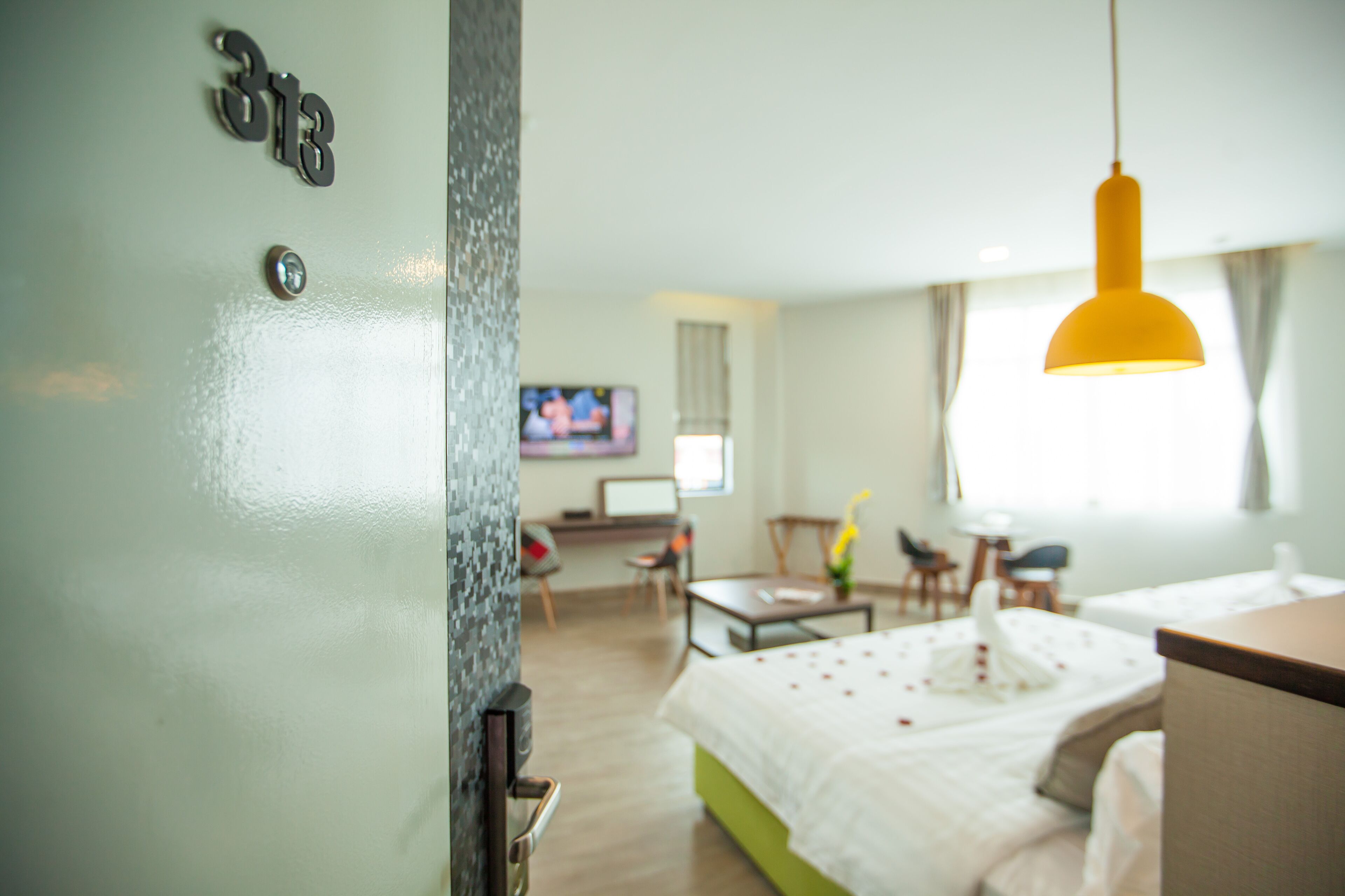 A hotel room with a bed, a desk, a TV, and a window.
