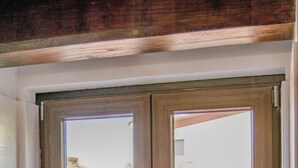 A bathroom with a wooden window, a towel stack, and a soap dispenser. - Sleep and go Hotel (Fiumicino)