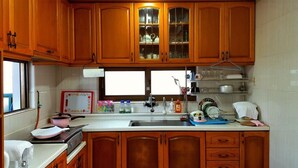Una cocina con armarios de madera, un lavamanos de acero inoxidable y una ventana sobre la encimera.