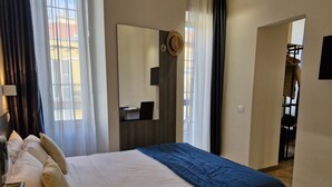 Una habitación de hotel con cama, escritorio y espejo.