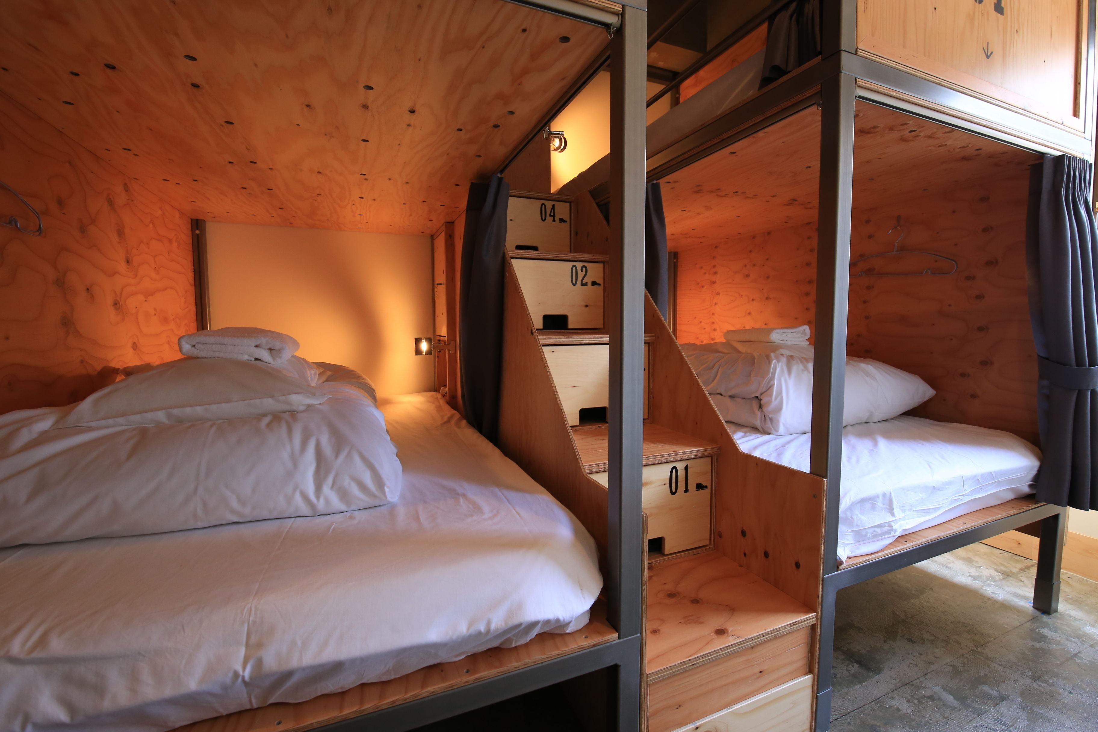 Une petite pièce de style cabane en bois, avec des lits superposés et un petit placard.