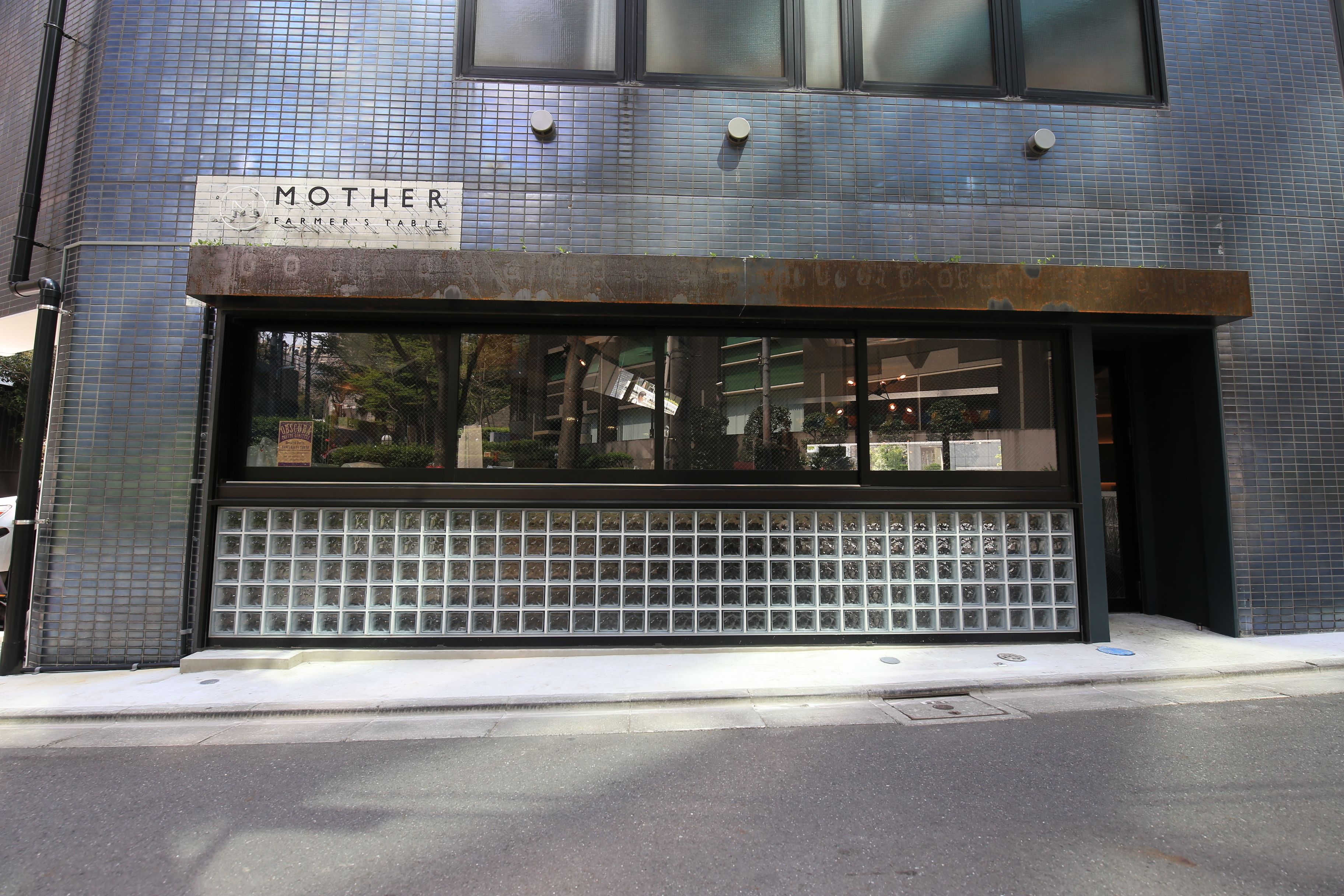 A building facade with a sign reading "MOTHER FARMER'S TABLE".
