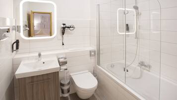 A modern bathroom with a glass-enclosed shower, a white sink, and a toilet.
