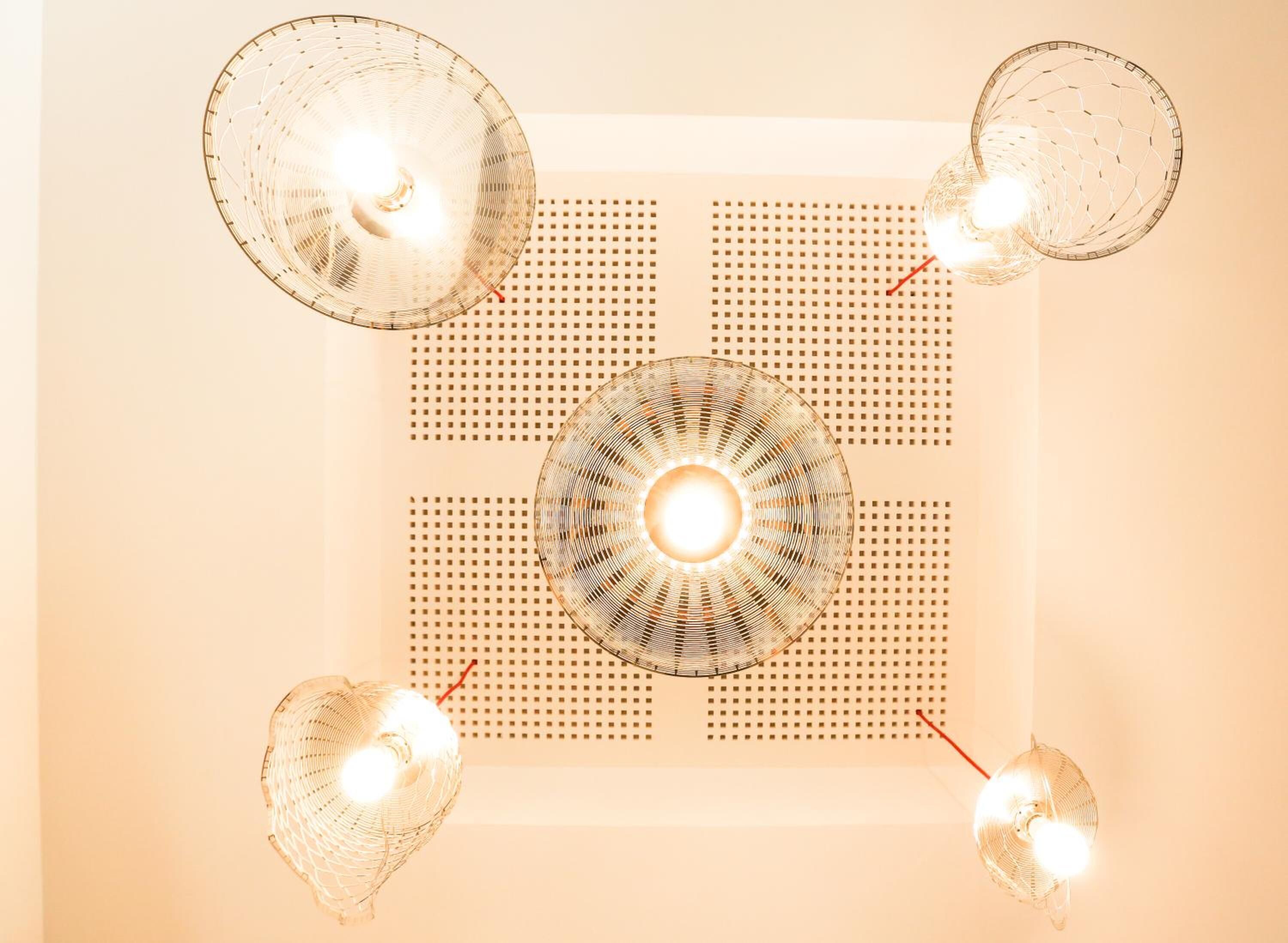 A ceiling with four spherical light fixtures and a central circular light fixture.