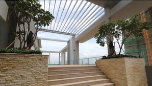 Ein modernes Interieur mit Glasdecke, Steintreppe und Zimmerpflanzen.