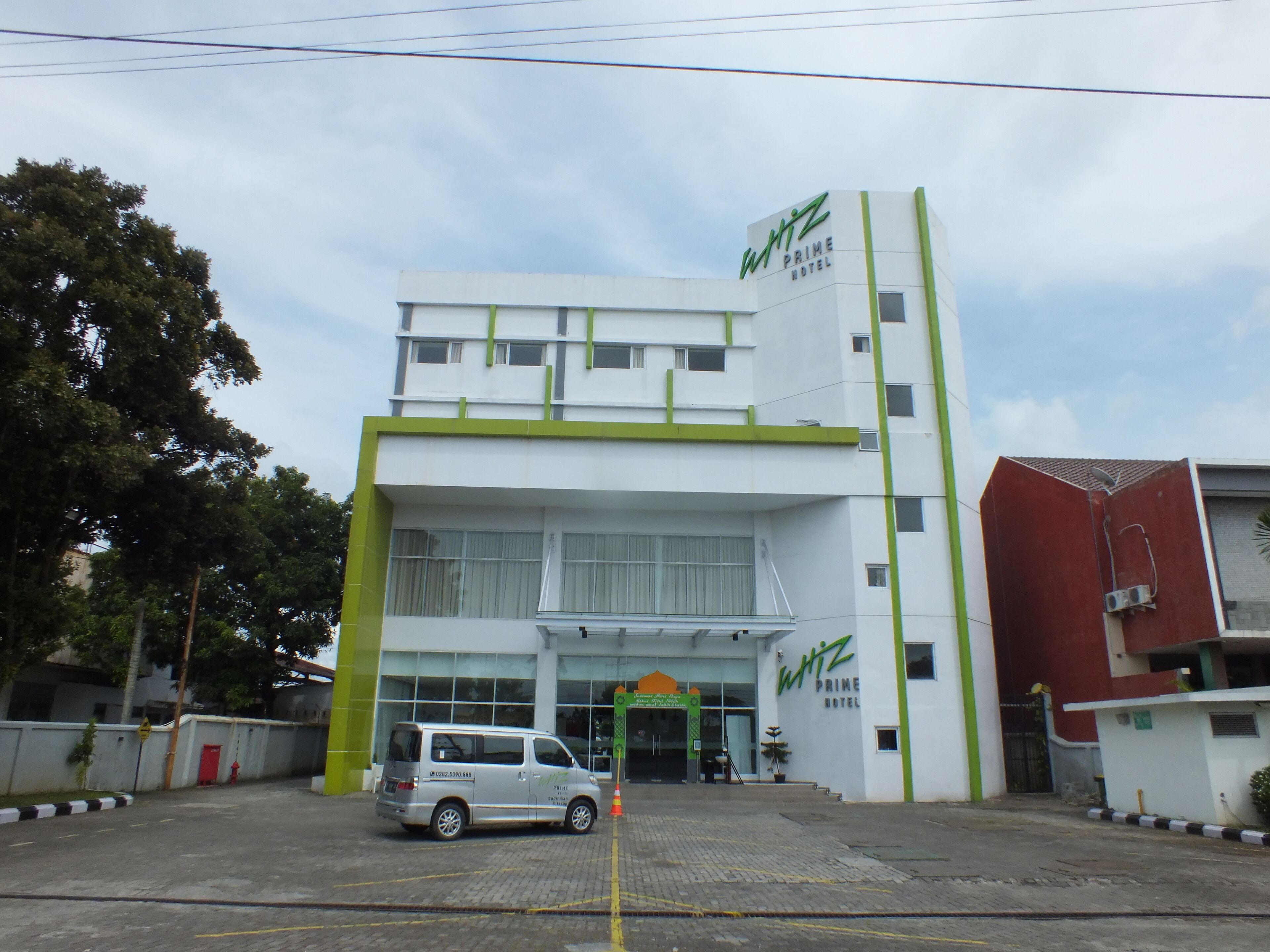 A modern building with a prominent sign for the Whiz Prime Hotel.