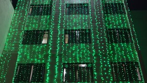 A hotel facade with green decorative lights and a 'HOTEL' sign. - Hotel Rahil Palace (Varanasi)