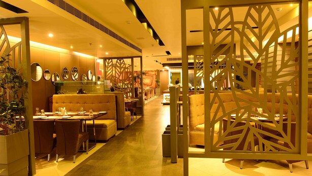 A hotel lobby with a reception desk, seating areas, and decorative panels. - Hotel Shoolin Grand (Guwahati)