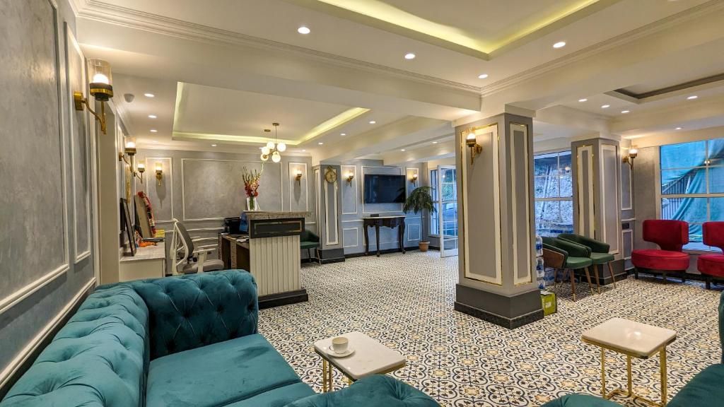 Een hotellobby met een zithoek, een receptiebalie en een televisie.
