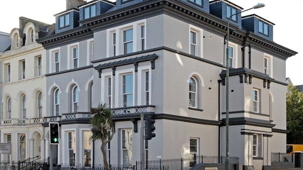 A large, historic building with multiple stories, prominent windows, and a flat roof. - Austen's Luxury Apartments (Torquay)