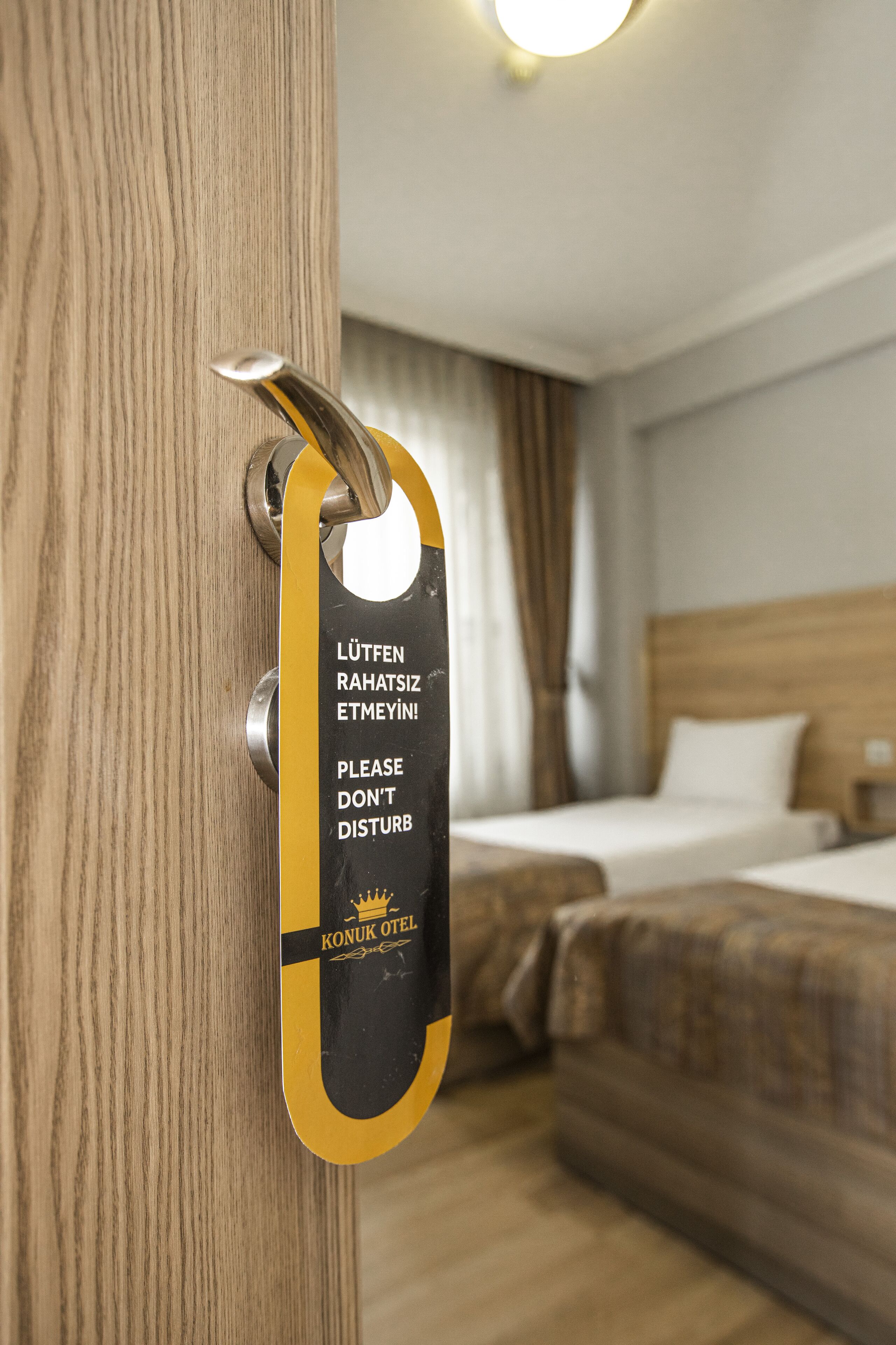 Une porte de chambre d’hôtel avec un panneau indiquant, dans plusieurs langues, de ne pas déranger.