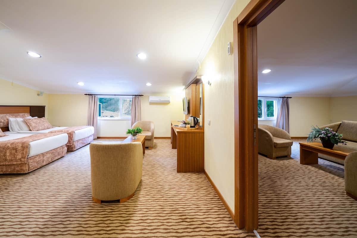 Ein Hotelzimmer mit einem Bett, einer Couch, einem Schreibtisch und einem Sessel.