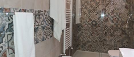 A bathroom with a shower, toilet, and sink.