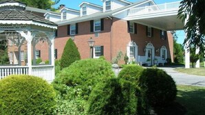 A large brick building with a covered porch and a gazebo in the foreground. - Smoketown Inn (Smoketown)
