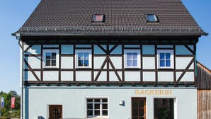 En traditionel bindingsværksbygning med et skilt, der viser teksten "BACKEREI" på facaden.