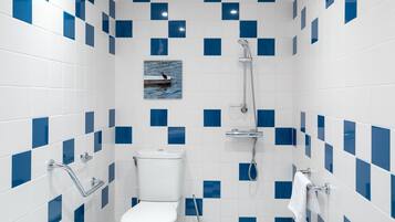 Une salle de bain avec des toilettes blanches, une douche et un porte-serviettes.