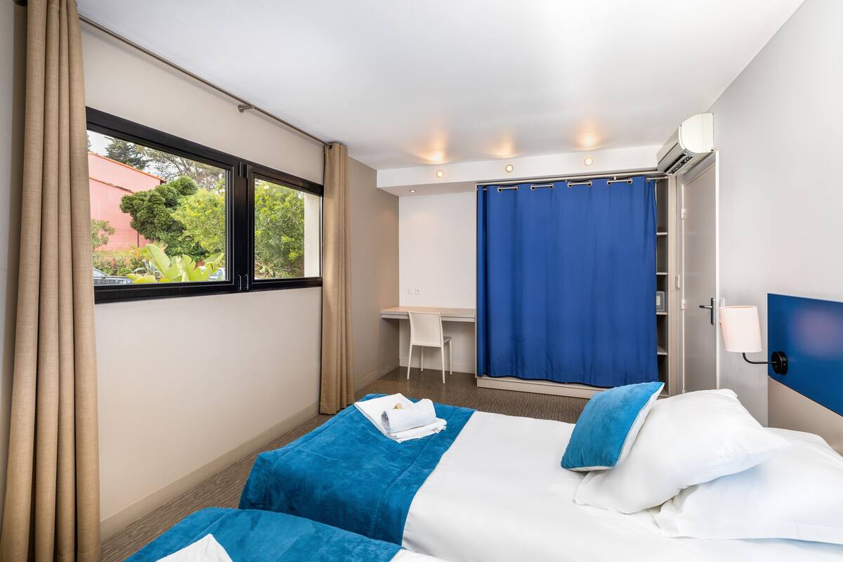 Une chambre d’hôtel équipée d’un lit, d’un bureau et d’un espace douche.